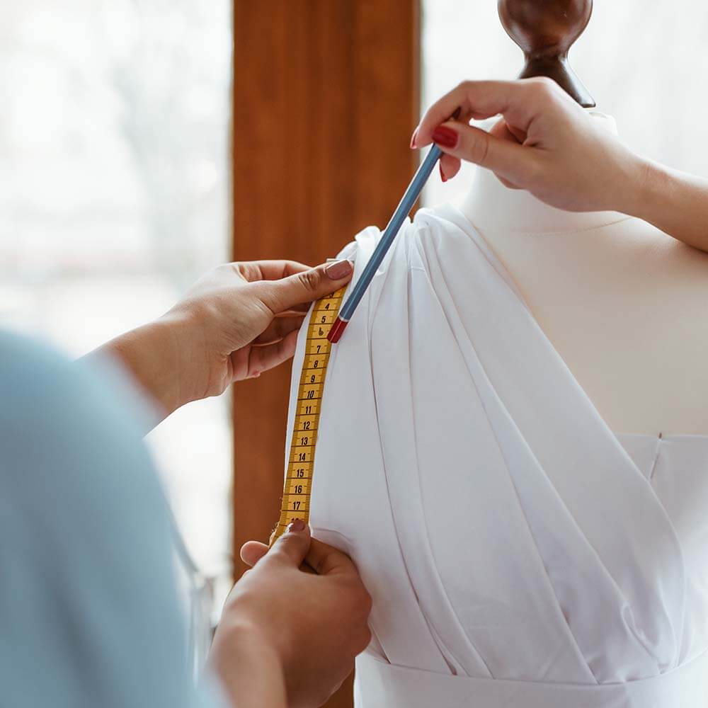home page close up of taking measurements for new dress.